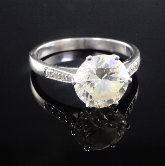 A white gold and single stone diamond ring with graduated diamond set shoulders, size O.